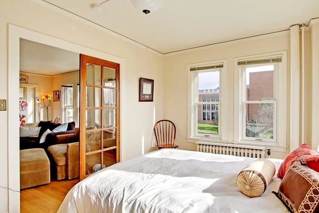 Bed with pillows living room through door bedroom at Commodore Duchess Apartments in Seattle Student Accommodation