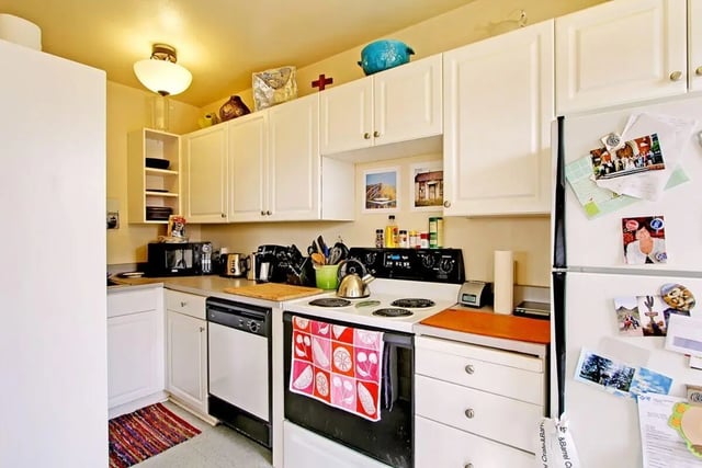 White cabinets stove dishwasher refrigerator kitchen at Commodore Duchess Apartments in Seattle Student Accommodation