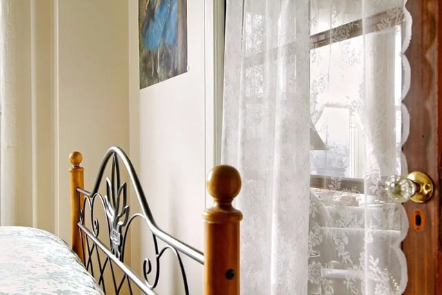 Metal bed frame lace curtains glass doorknob bedroom at Commodore Duchess Apartments in Seattle Student Accommodation