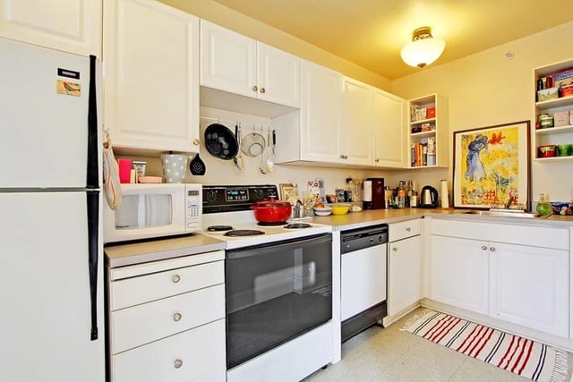 White refrigerator microwave stove dishwasher kitchen at Commodore Duchess Apartments in Seattle Student Accommodation