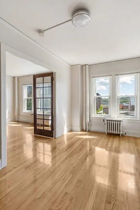 Wooden floor with glass door windows and radiator Living room at Commodore Duchess Apartments in Seattle Student Accommodation