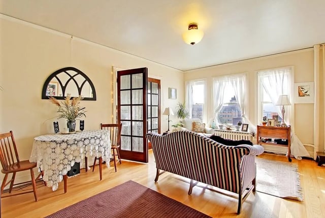 Sofa table chairs mirror and door living room at Commodore Duchess Apartments in Seattle Student Accommodation