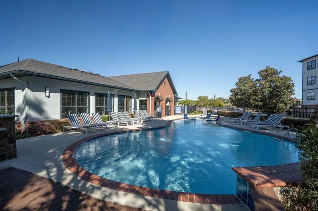 Pool with lounge chairs and umbrellas exterior at Midtown 905 in Denton Student Accommodation
