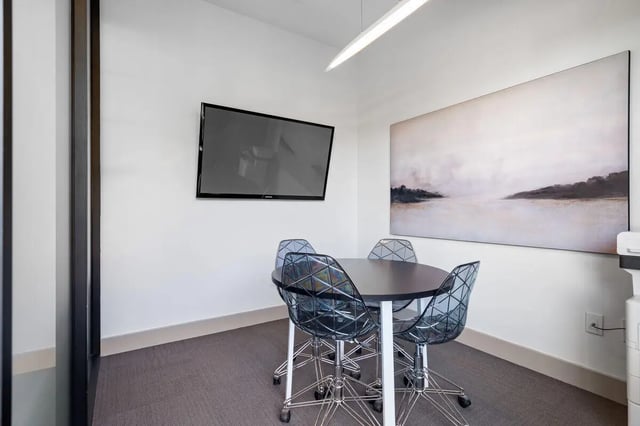 Round table four clear chairs large painting television study area at Midtown 905 in Denton Student Accommodation