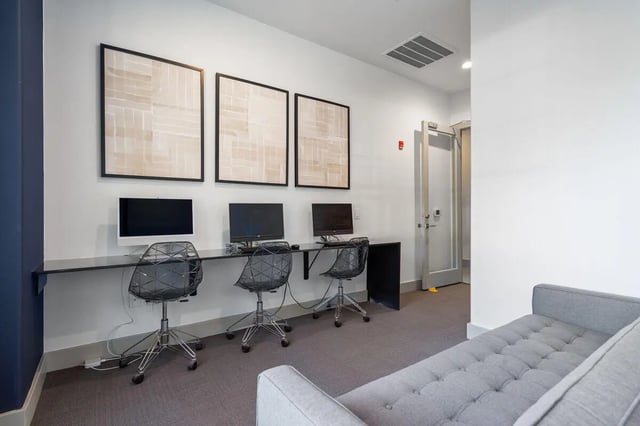Computers chairs artwork gray couch study area at Midtown 905 in Denton Student Accommodation