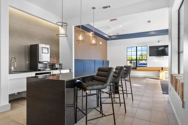 Coffee machine sink counter bar stools and lounge area kitchen at Midtown 905 in Denton Student Accommodation
