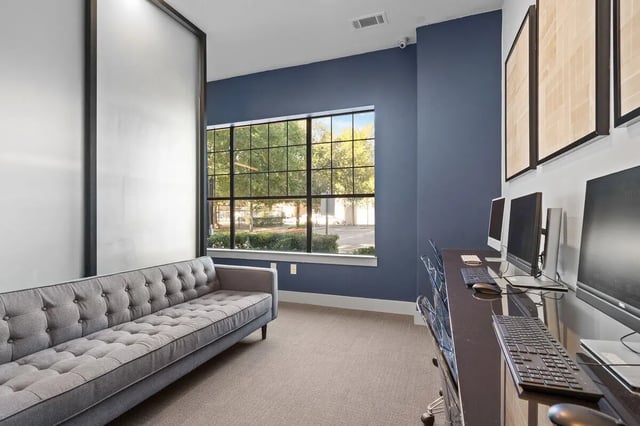 Tufted sofa computers and framed art study area at Midtown 905 in Denton Student Accommodation