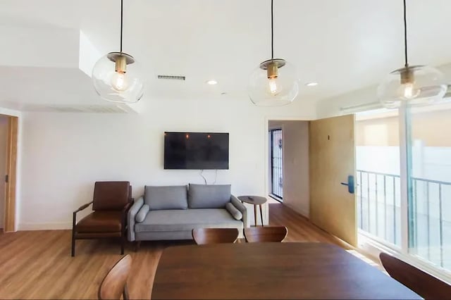 Sofa chairs TV dining table pendant lights living room at 1329 W 36th St in Los Angeles Student Accommodation