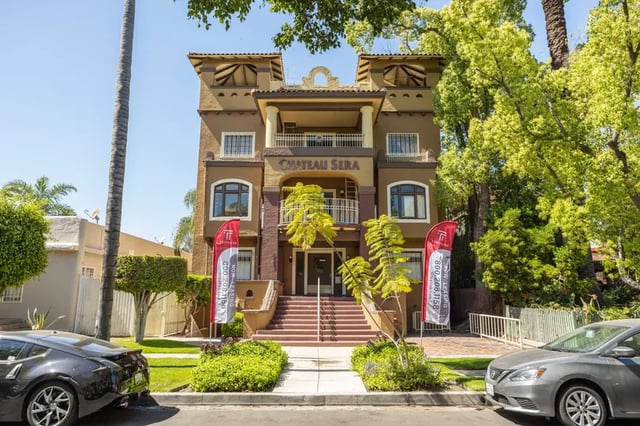Chateau Sera building with entrance stairs and cars exterior at 1329 W 36th St in Los Angeles Student Accommodation
