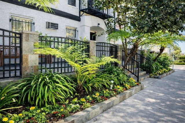 Lush plants and flowers border building exterior at 1329 W 36th St in Los Angeles Student Accommodation
