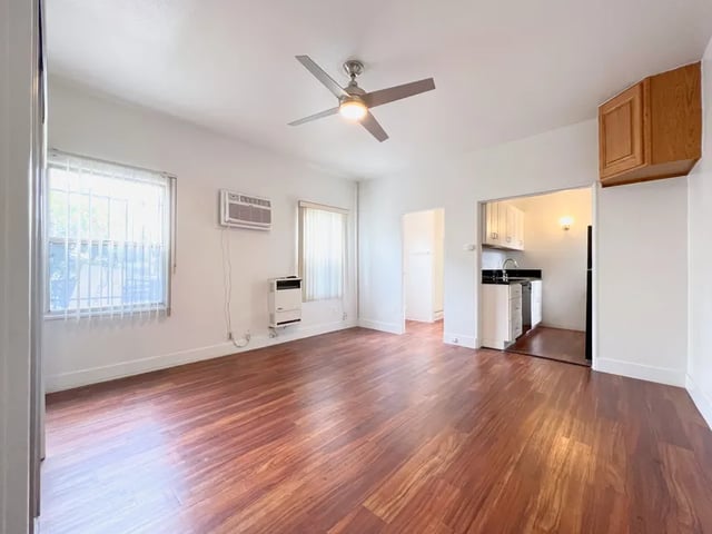 Empty room with wood floors and open kitchen at 1329 W 36th St in Los Angeles Student Accommodation