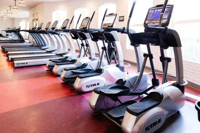 Ellipticals and treadmills in a fitness room at The Scarlet in Lubbock Student Accommodation