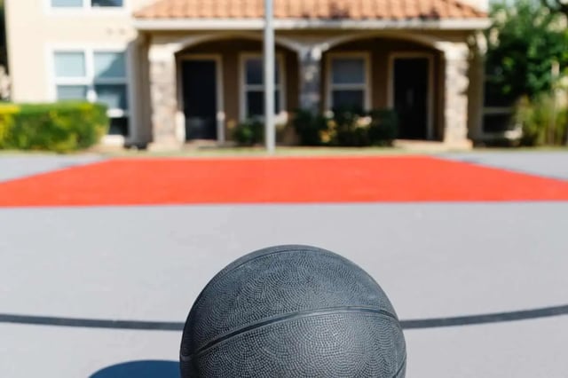 Basketball on court with building exterior at The Scarlet in Lubbock Student Accommodation