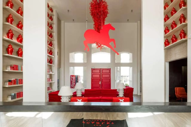 Red sofa Coca-Cola sign horse art lobby at The Scarlet in Lubbock Student Accommodation