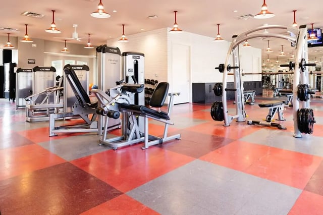 Weight machines, benches, and weights in gym. at The Scarlet in Lubbock Student Accommodation