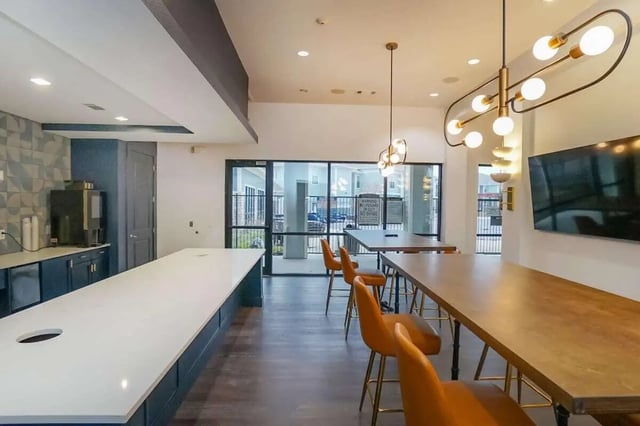 Kitchenette long counter orange stools and tables communal area at The Domain at Columbia in Columbia Student Accommodation
