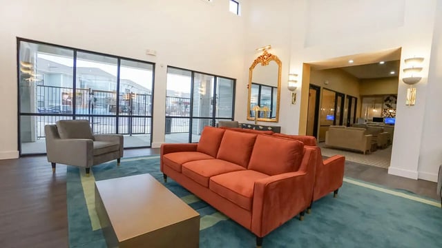 Orange sofa grey armchair coffee table living room at The Domain at Columbia in Columbia Student Accommodation