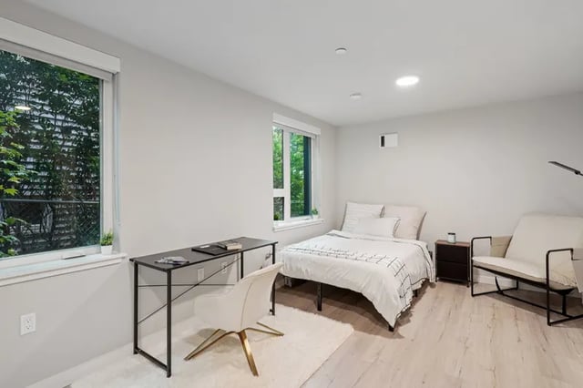 Bed desk chair and sofa bedroom at Clara Apartments in Seattle Student Accommodation