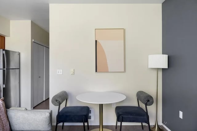 Table chairs painting floor lamp kitchen living room at Clara Apartments in Seattle Student Accommodation