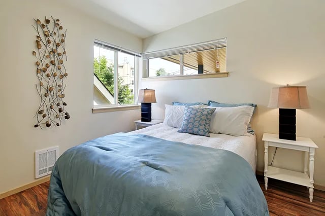 Bed with blue cover bedside lamps bedroom at Clara Apartments in Seattle Student Accommodation