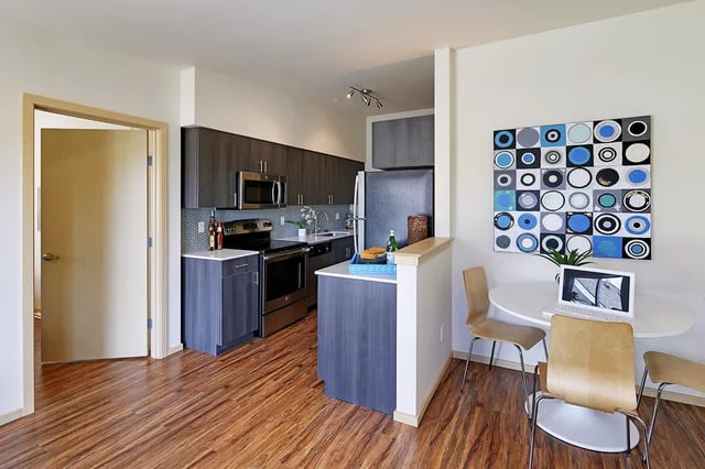 Modern kitchen with dining area and laptop at Clara Apartments in Seattle Student Accommodation