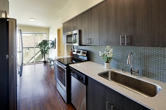 Stainless steel refrigerator stove dishwasher sink kitchen at Clara Apartments in Seattle Student Accommodation