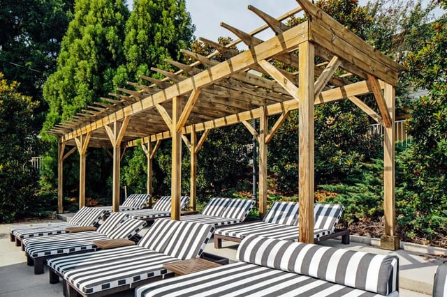 Lounge chairs under wooden pergola outdoor living area at The Vic in Greensboro Student Accommodation
