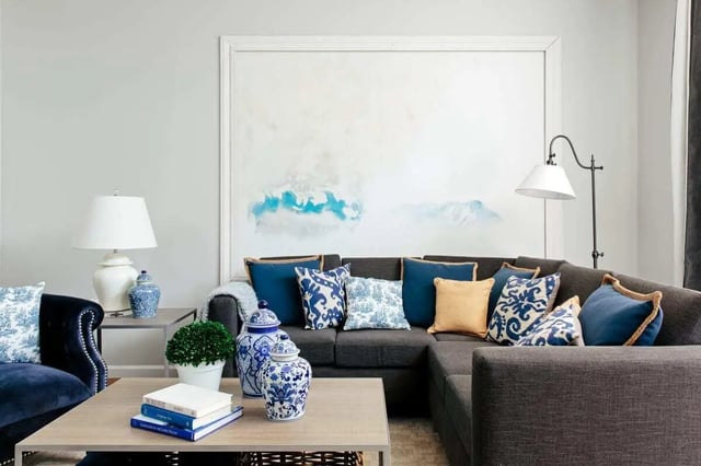 Dark sectional couch with patterned pillows abstract painting living room at The Vic in Greensboro Student Accommodation
