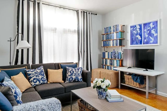 Lounge area with sectional sofa bookshelves and television living room at The Vic in Greensboro Student Accommodation