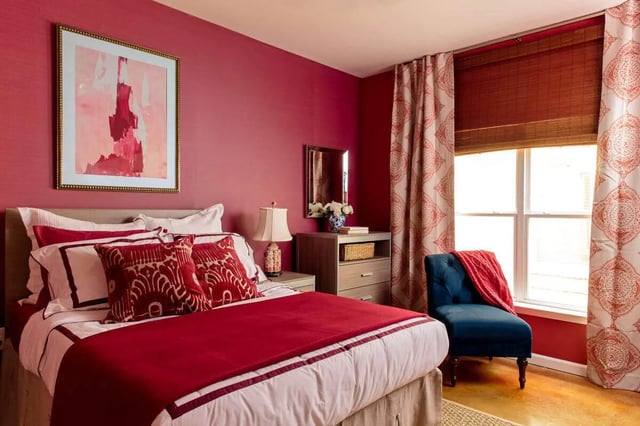 Red bedding framed art blue chair bedroom at The Vic in Greensboro Student Accommodation
