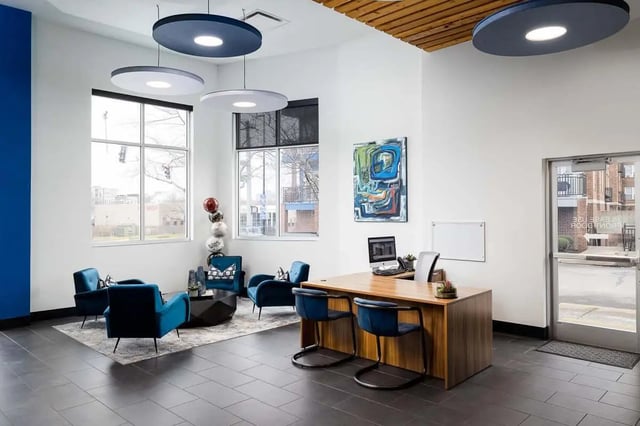 Office lobby with desk chairs artwork and seating area lobby at The Lex in Lexington Student Accommodation