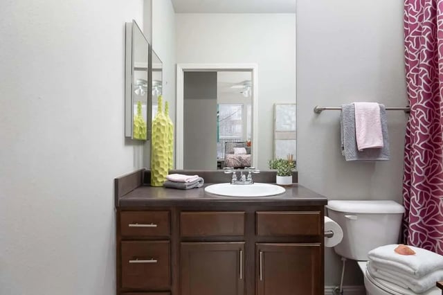 Sink mirror vanity with bottles and towels bathroom at The Lex in Lexington Student Accommodation