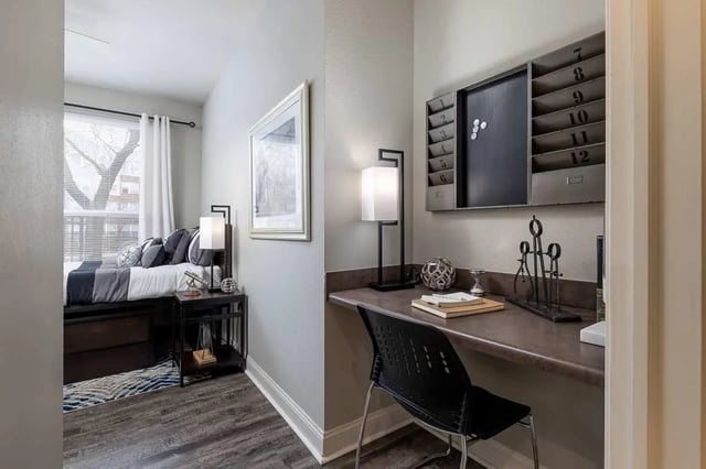 Bed with striped pillows desk with chair bedroom and study at The Lex in Lexington Student Accommodation