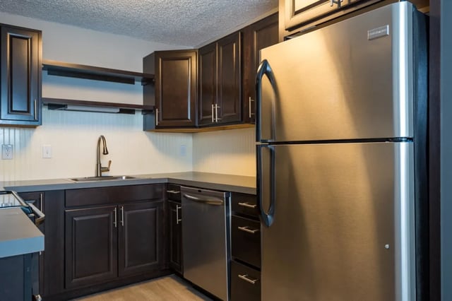 Stainless steel refrigerator dishwasher dark cabinets kitchen at Connery Place Apartments in Portland Student Accommodation