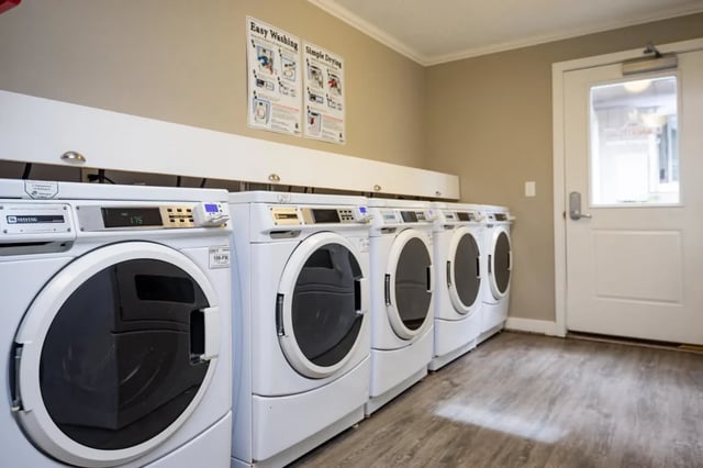 Row of white washing machines laundry area at Connery Place Apartments in Portland Student Accommodation