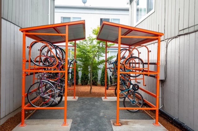 Orange bike racks hold multiple bicycles exterior image at Connery Place Apartments in Portland Student Accommodation