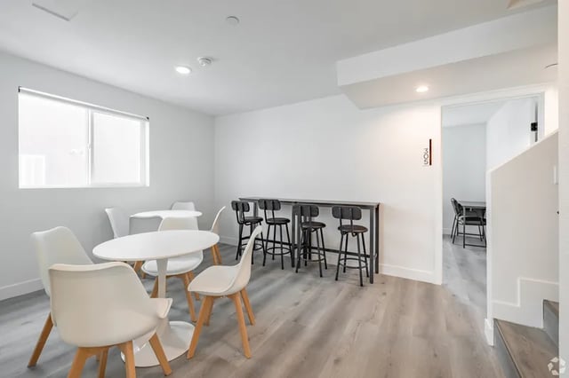 White tables and chairs with bar stools communal area at 1360 W 35th St in Los Angeles Student Accommodation