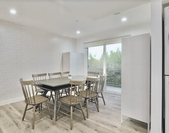 Dining table and chairs with patterned wallpaper living area at 1360 W 35th St in Los Angeles Student Accommodation