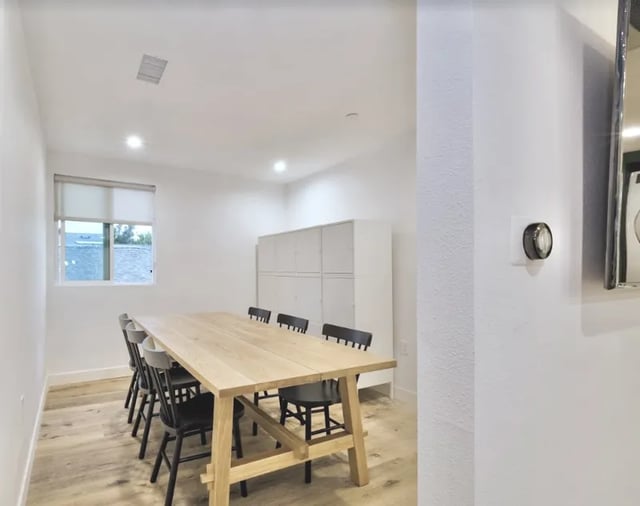 Wooden table chairs lockers and window common area at 1360 W 35th St in Los Angeles Student Accommodation