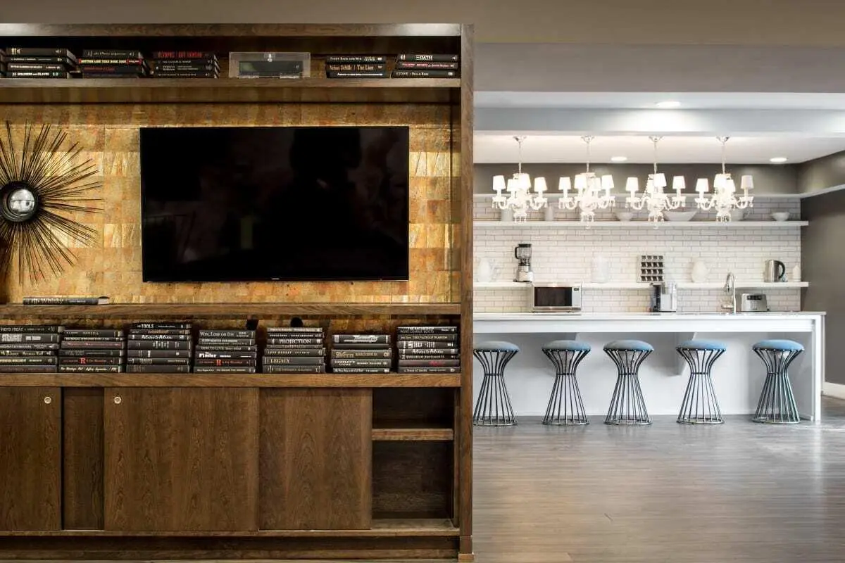 TV books sunburst mirror kitchen counter stools kitchen at The Harrison in Harrisonburg Student Accommodation