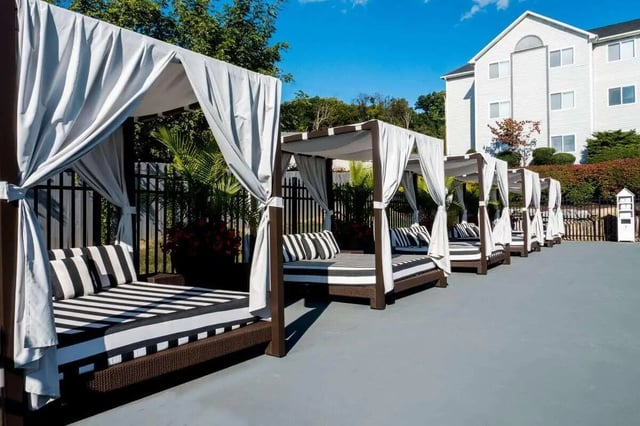 Daybeds with striped cushions outside building Exterior at The Harrison in Harrisonburg Student Accommodation