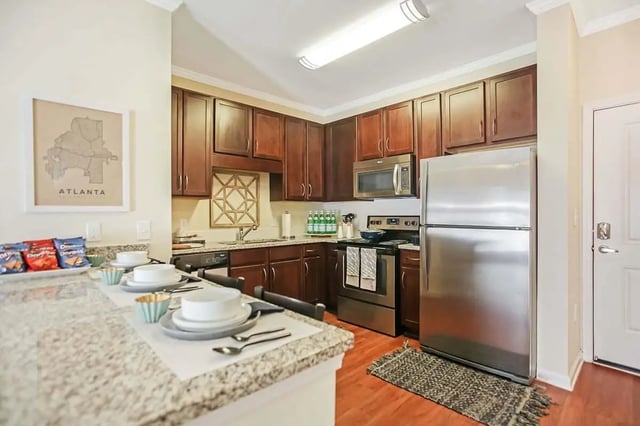 Kitchen with stainless steel appliances and dark cabinets kitchen at West 22 in Kennesaw Student Accommodation