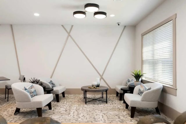 White armchairs central coffee table patterned rug living area at West 22 in Kennesaw Student Accommodation