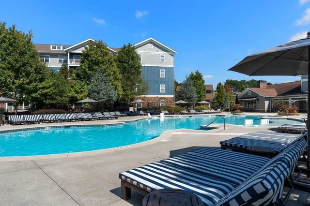 Pool with lounge chairs and buildings exterior at West 22 in Kennesaw Student Accommodation