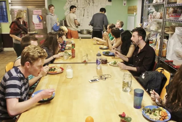 People eating at a long wooden table dining area at Berkeley Student Cooperative - Affordable Student Housing Co-op in Berkeley Student Accommodation