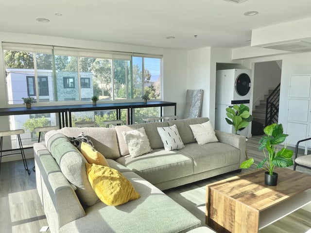 Sectional sofa coffee table and plants Living room at 1476 W 35th St in Los Angeles Student Accommodation