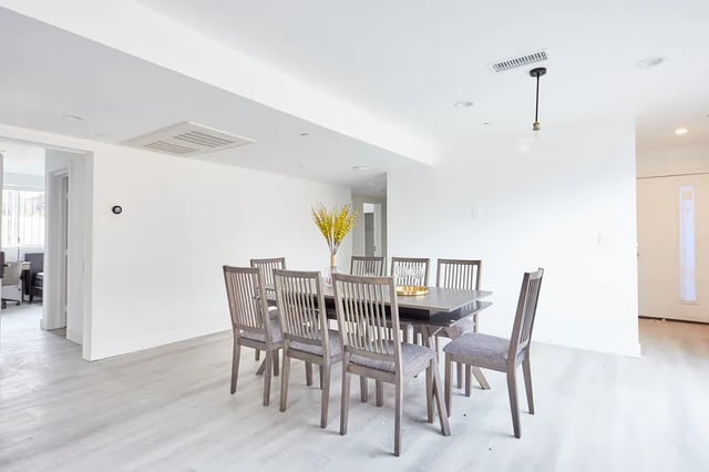 Dining table with eight chairs and flowers dining room at 1476 W 35th St in Los Angeles Student Accommodation