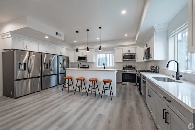 Four fridges white counter bar stools kitchen area at 1476 W 35th St in Los Angeles Student Accommodation