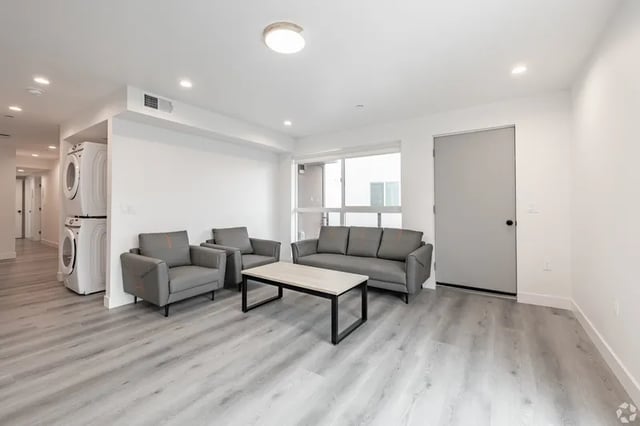Gray sofa and armchairs with coffee table living room at 1476 W 35th St in Los Angeles Student Accommodation