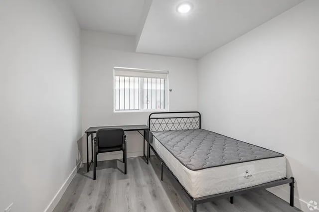 Bed desk chair window bare walls bedroom at 1476 W 35th St in Los Angeles Student Accommodation